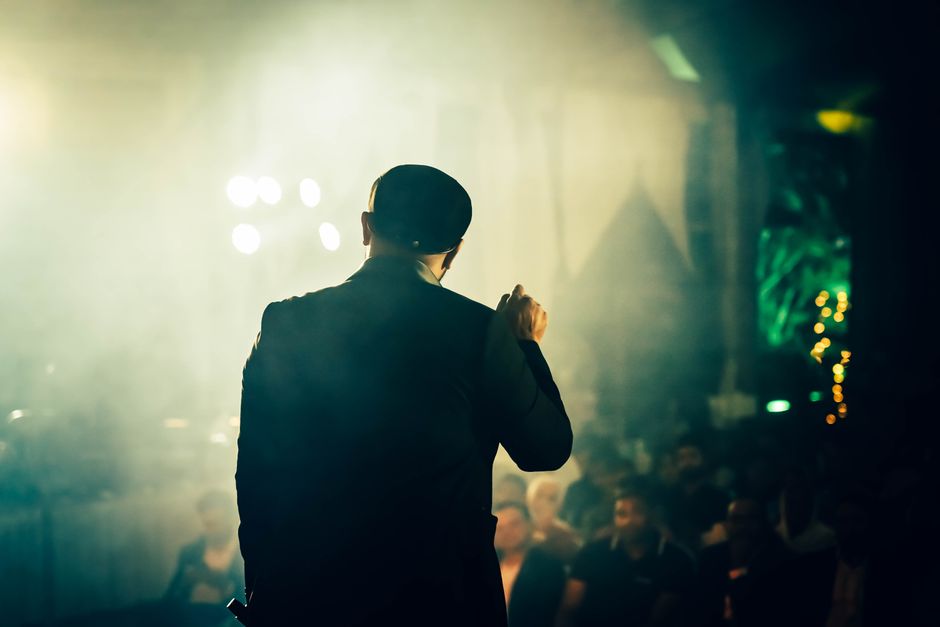 Voditelj govori publici na atmosferičnom mjestu za zabavu